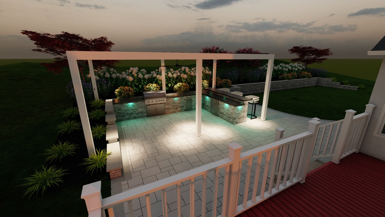 Modern outdoor kitchen with grill, counters, and stools surrounded by lush garden in a landscaped backyard, viewed from a deck at dusk.