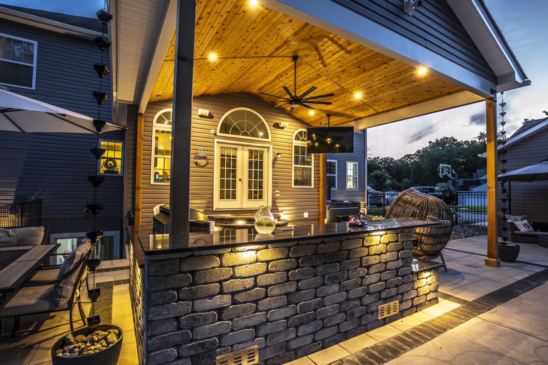 An outdoor kitchen and dining area with refined lighting that creates a luxurious atmosphere.