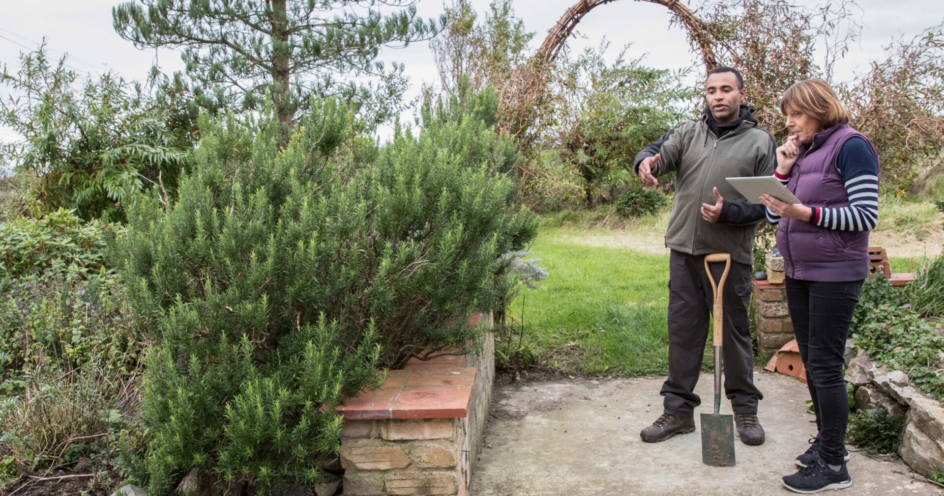 Landscape gardener advising a customer regarding her garden plot